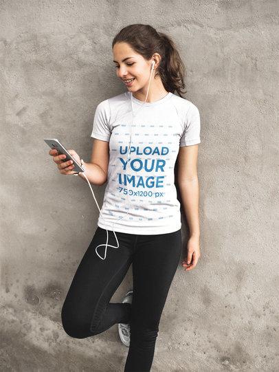 Sports Mockup of a Girl Listening to Music Against Concrete Wall While Wearing Custom Activewear